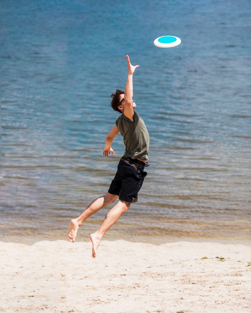 adult man jumping catching frisbee